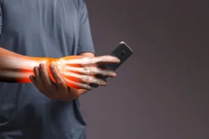 Hand holding a smartphone with an X-ray style overlay showing wrist bones and highlighting nerve-related pain.